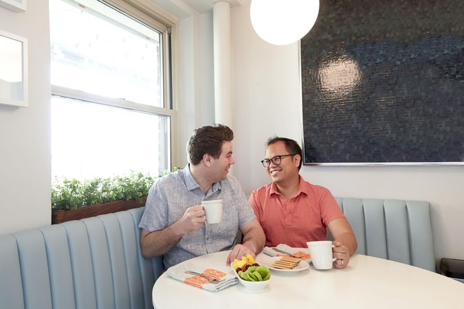 Gay couple sitting at a table drinking coffee