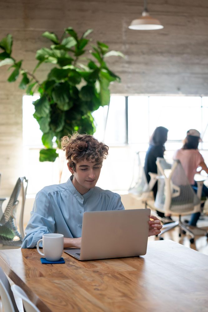 Person in open workspace with laptop and coffee