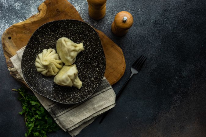 Top view of plate of traditional Georgian khinkali dumplings with copy space