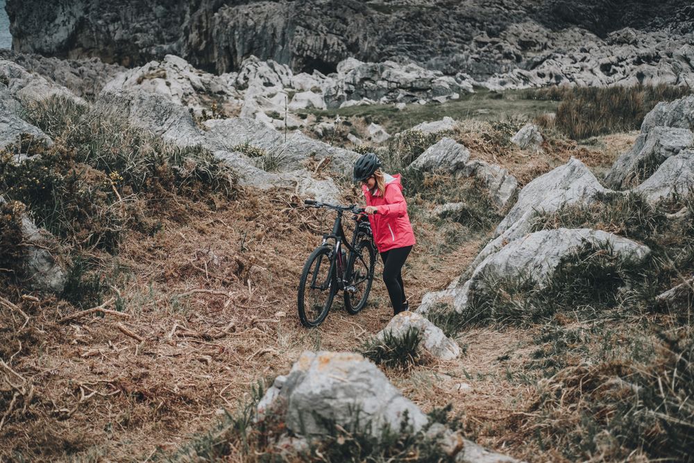Anonymous female bicyclist on rocks