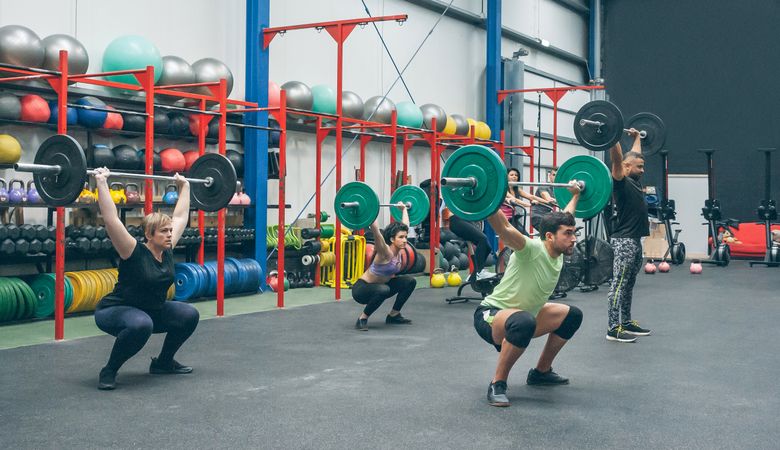 People practicing weightlifting lifting weights in the gym