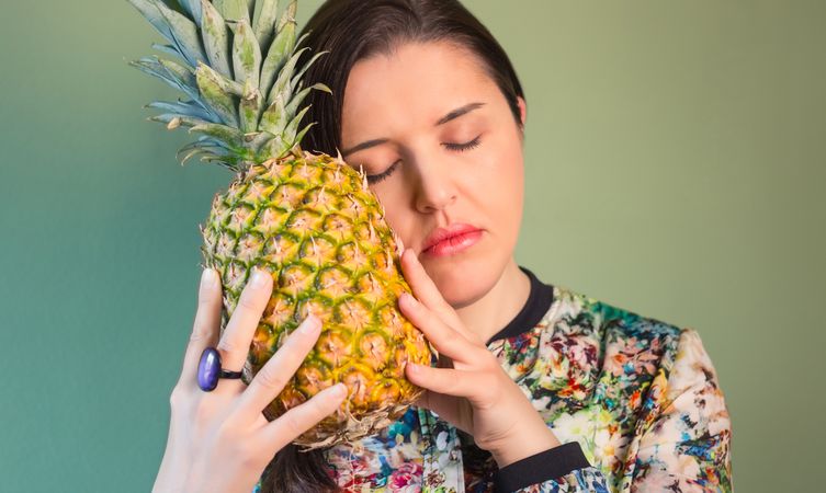 Woman dreaming with pineapple in her hands