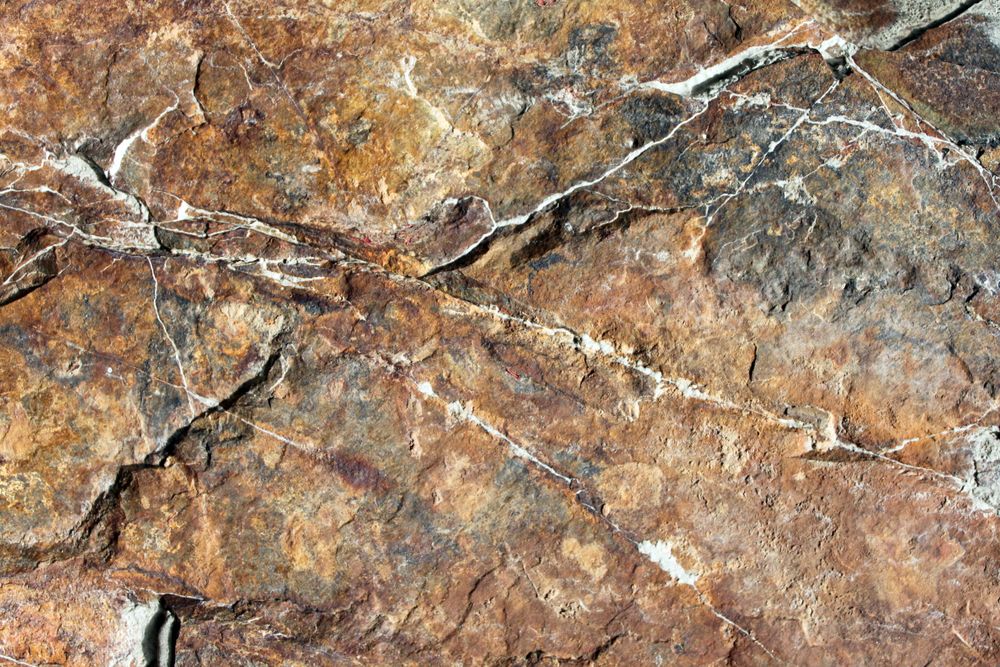 Dark amber colored rock face with strings