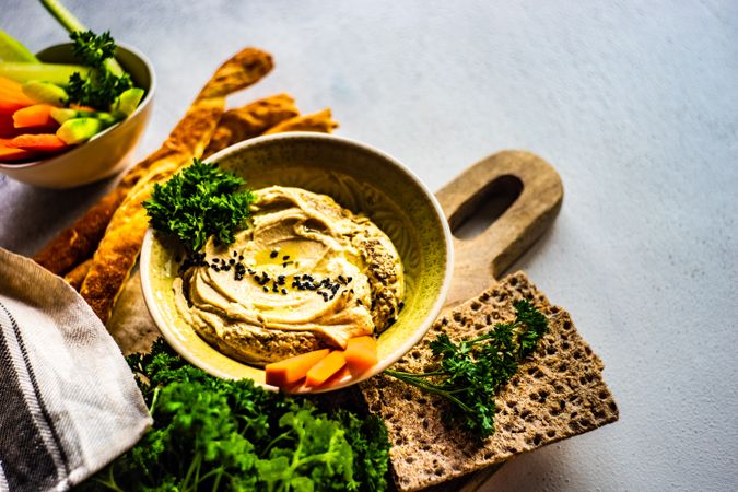 Traditional hummus spread with veggies and crackers to dip