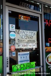 “No mask no entry” sign on restaurant door window 47mva0