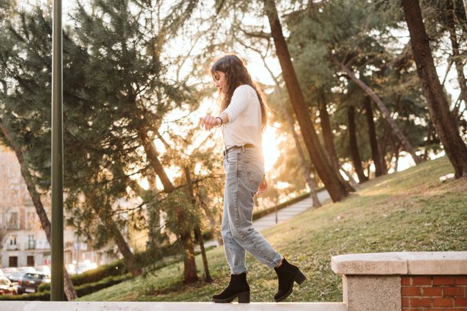 Young woman walking on border in park