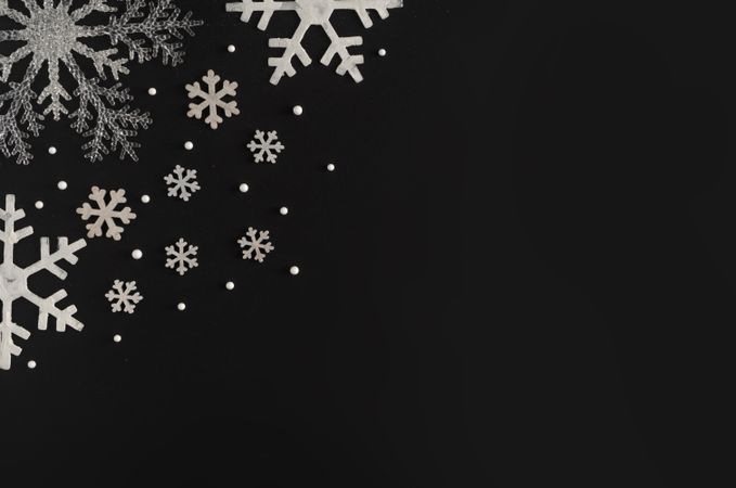 Silver holiday snowflakes on dark background