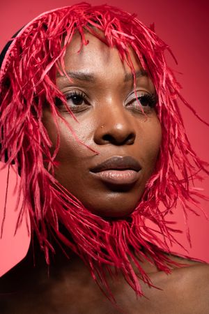 Portrait of woman wearing red nest to her face