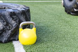 Heavy tires near kettlebell on lawn