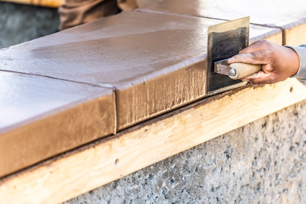 Construction Worker Using Stainless Steel Edger On Wet Cement Forming Coping Around New Pool