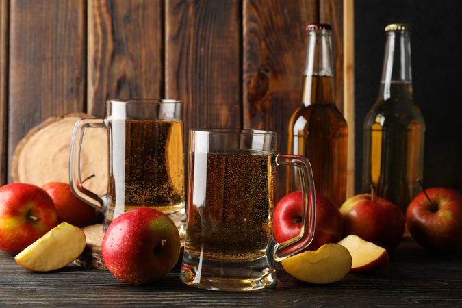 Composition with cider and apples on wooden background