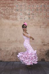 Passionate woman in flamenco dress dancing on street