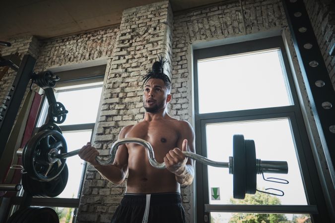 Black man exercising with barbell in gym