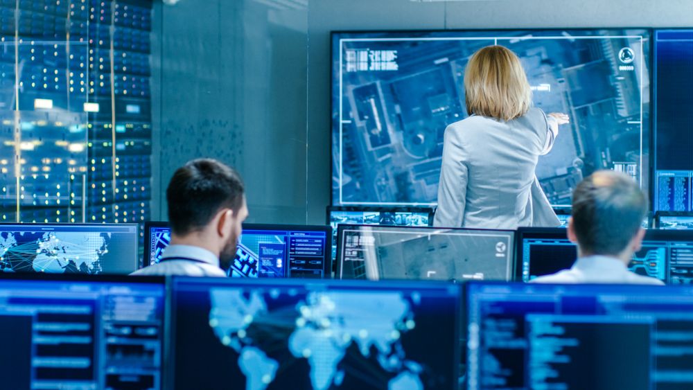 In the Government Surveillance Facility Team of Officers Organize Interception Plan with Help of Satellite Navigation.