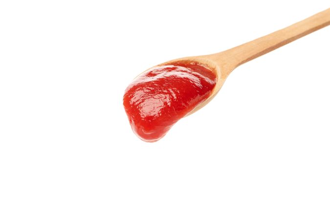 Wooden spoon with tomato sauce isolated on neutral background