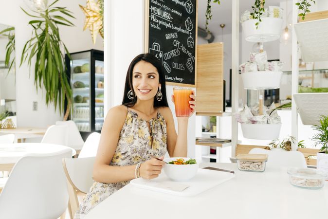 Cheerful woman with healthy food in cafe