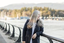 Woman wearing a blazer leaning on a railing