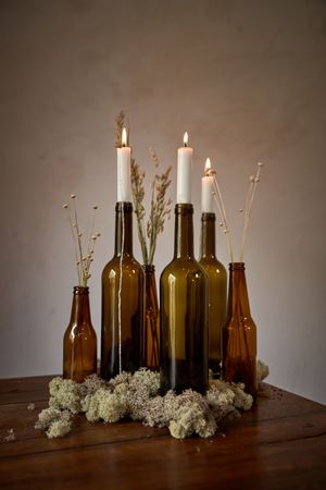 Empty bottles with burning candles
