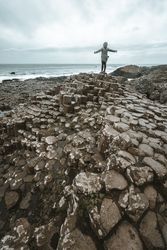 Female standing on cliff and contemplating