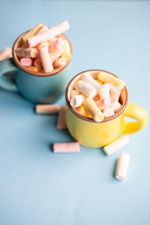 Two pastel mugs full of marshmallow