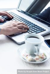 Person working on laptop on desk with cup of coffee 5p6Jxb