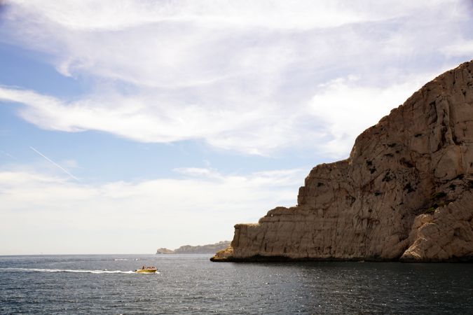 Limestone rocks and boat sailing in sea