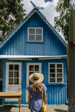 Young woman standing in front of country house