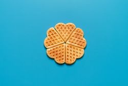 Homemade waffles top view, isolated on a blue background