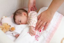Hands of mother holding her baby girl sleeping