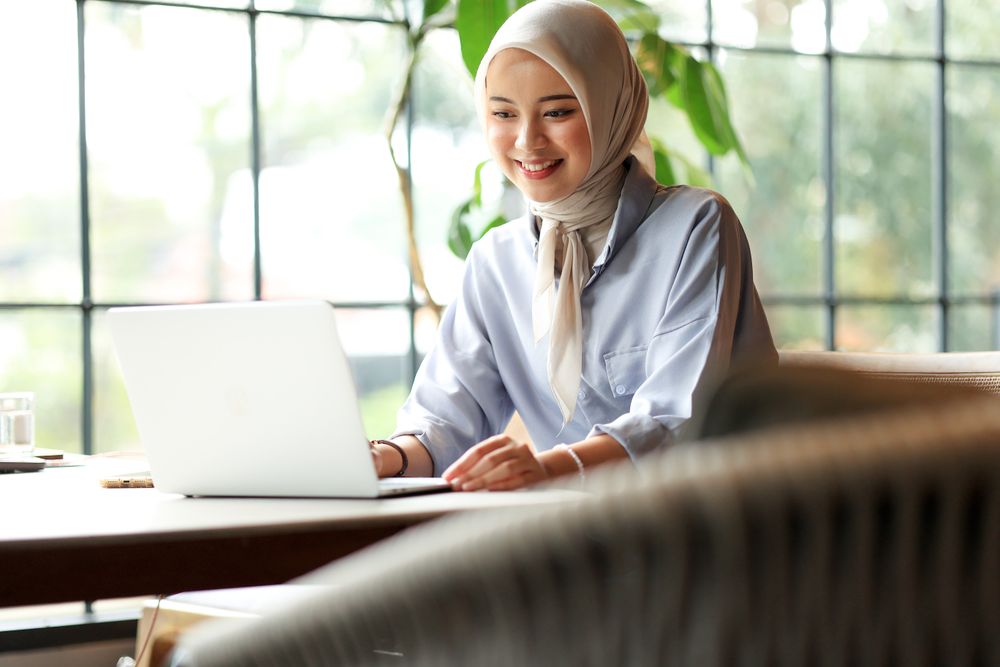Young Asian Muslim Business Woman Wearing Hijab Working  with Laptop