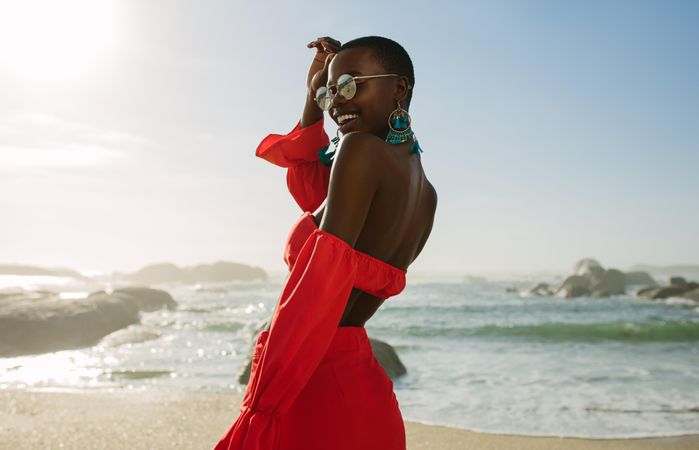 Beautiful woman in red dress enjoying on the beach