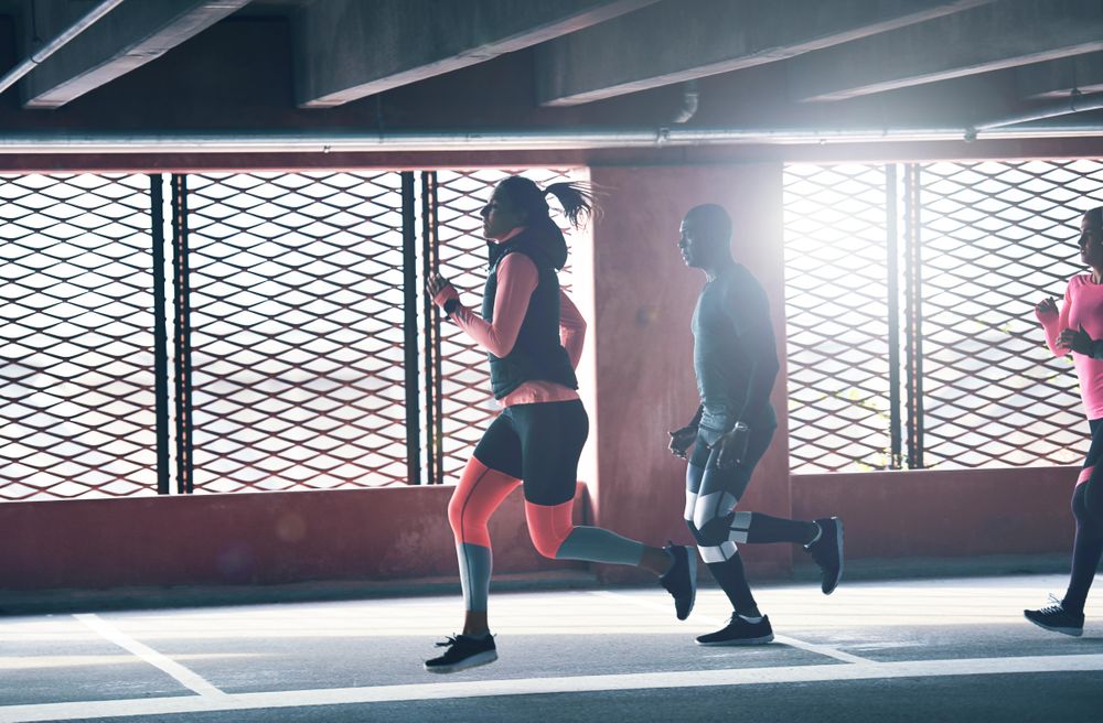 People running in indoor track near window