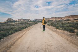 Man standing on road in desert hills