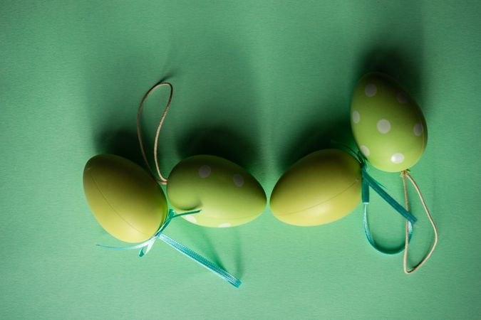 Easter holiday card concept with green ornamental eggs scattered on green background