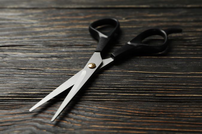 hairdresser scissors on wooden background, close up