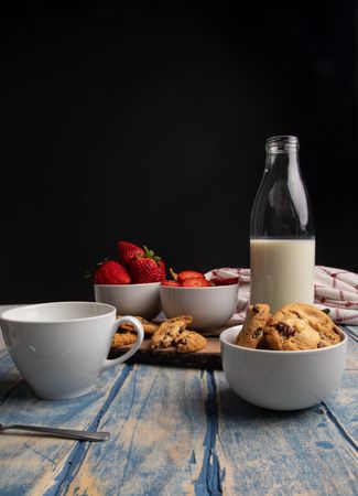 Glasses near fruits and cookies on table near napkin