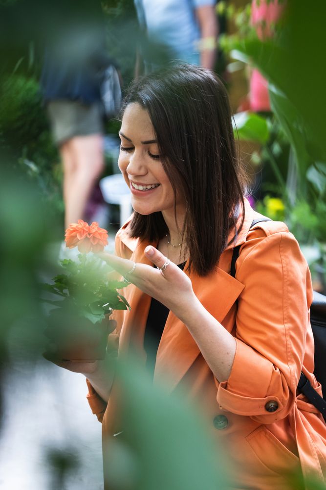 Cheerful woman choosing flowers in garden center