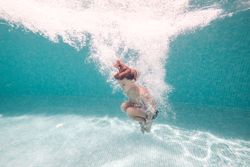 Underwater shot of boy jumping in pool water