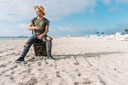 fit guy posing with a small suitcase