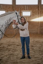 Rider with dapple gray horse in round arena