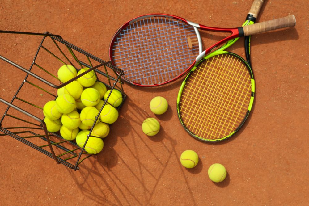 Tennis racquets with tennis balls on clay court