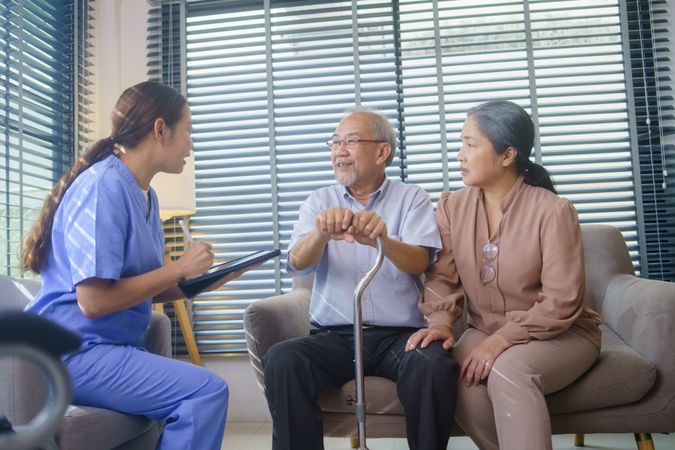 Asian nurse doing a check up for older Asian man at home