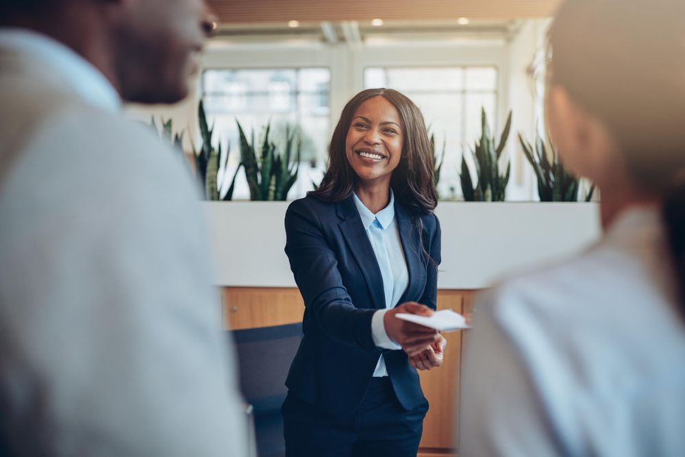 Woman sharing a note with two people in a business setting