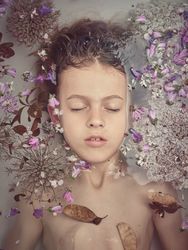 Boy in bath with colorful flowers