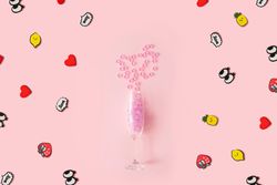 Champagne flute with pink plastic stars on pastel pink background with pop art stickers