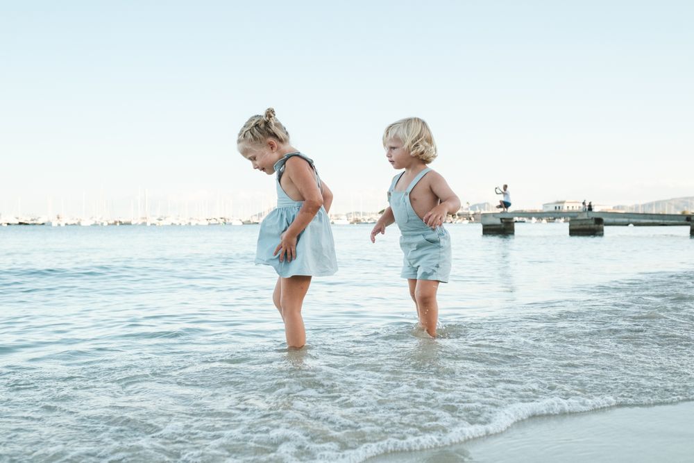 Happy kids walking in sea on beach