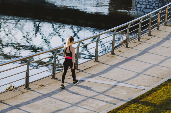Woman walking on embankment near water