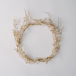 Thorny wreath made of branches on light background