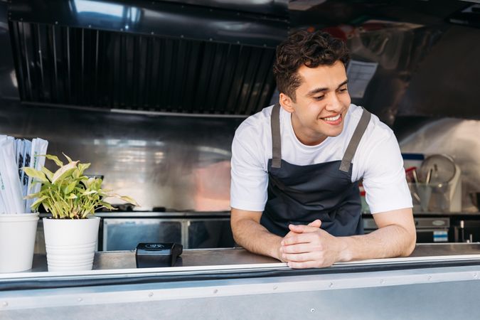 Food truck vendor smiling in van kitchen