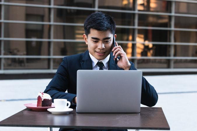 Cheerful Asian businessman working in cafe